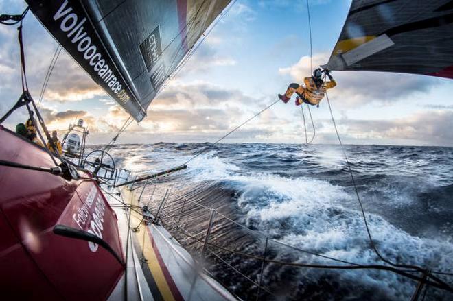 Onboard Abu Dhabi Ocean Racing - Luke Parko Parkinson swings out over the southern ocean to tie a changing sheet on the FRO at sunset - Leg five to Itajai -  Volvo Ocean Race 2015 © Matt Knighton/Abu Dhabi Ocean Racing